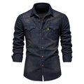 A dark indigo denim long-sleeve button-up shirt with two chest pockets and brown buttons, shown on a white background.
