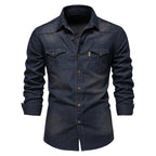 A dark indigo denim long-sleeve button-up shirt with two chest pockets and brown buttons, shown on a white background.
