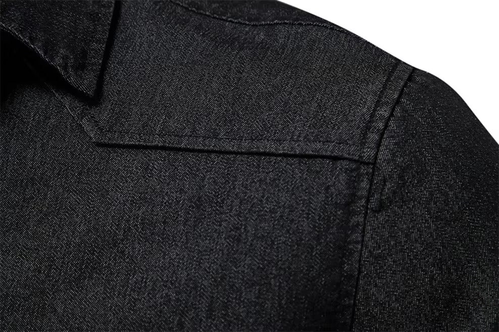 Close-up of a dark charcoal gray textured fabric, showing a collar and shoulder seam detail.